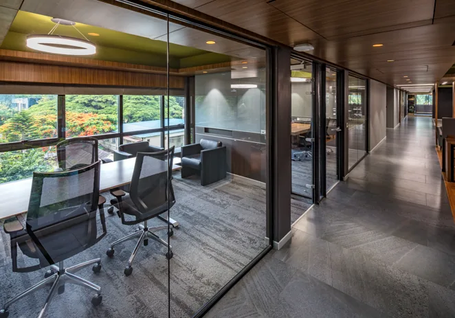 Glass meeting rooms and office corridor by Rizin Spaces